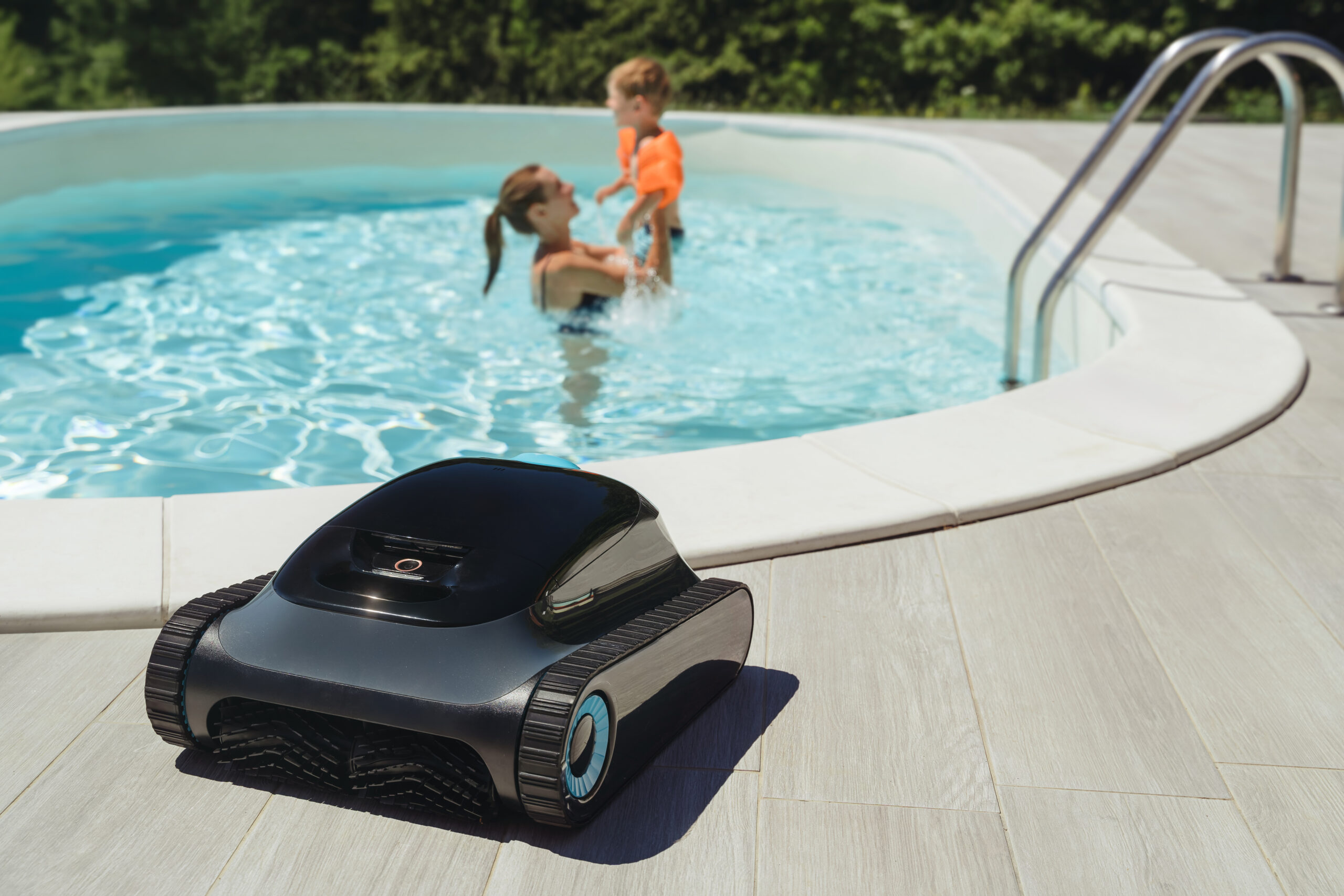 Robot nettoyeur de piscine posé sur le bord du bassin prêt à être utilisé