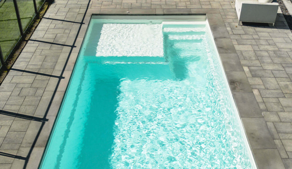 Tendances de piscine en 2026 : piscine avec plage immergée et marches, vue de haut sur eau turquoise
